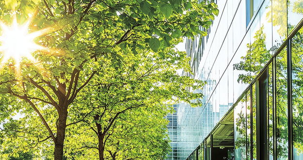 Energieeffizientes Bürogebäude Unternehmen mit Glasfront und Baum davor