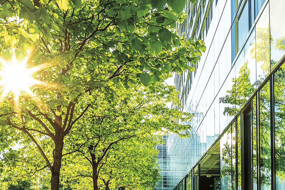 Energieeffizientes Bürogebäude Unternehmen mit Glasfront und Baum davor